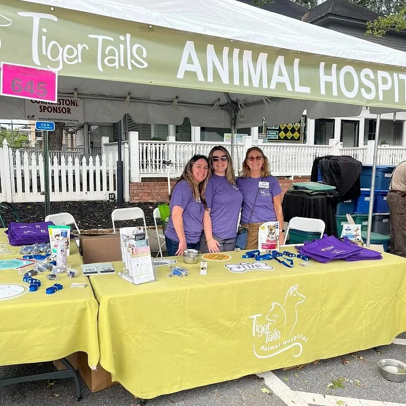 Team members standing behind a booth handing out swag