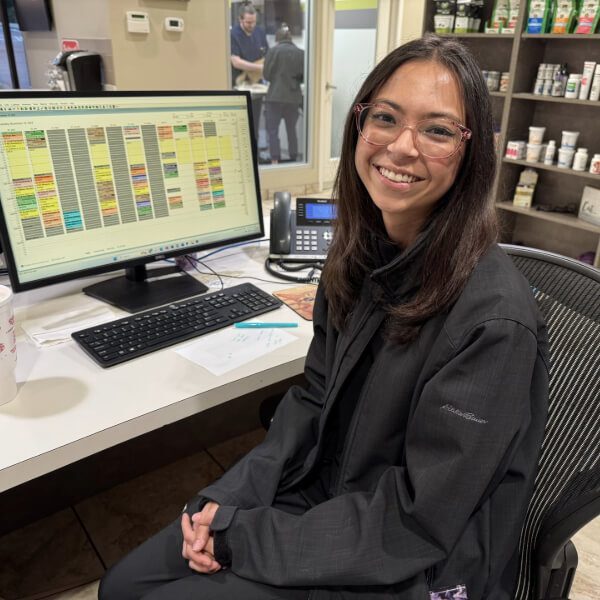 Female siting at computer wearing glasses and a black jacket